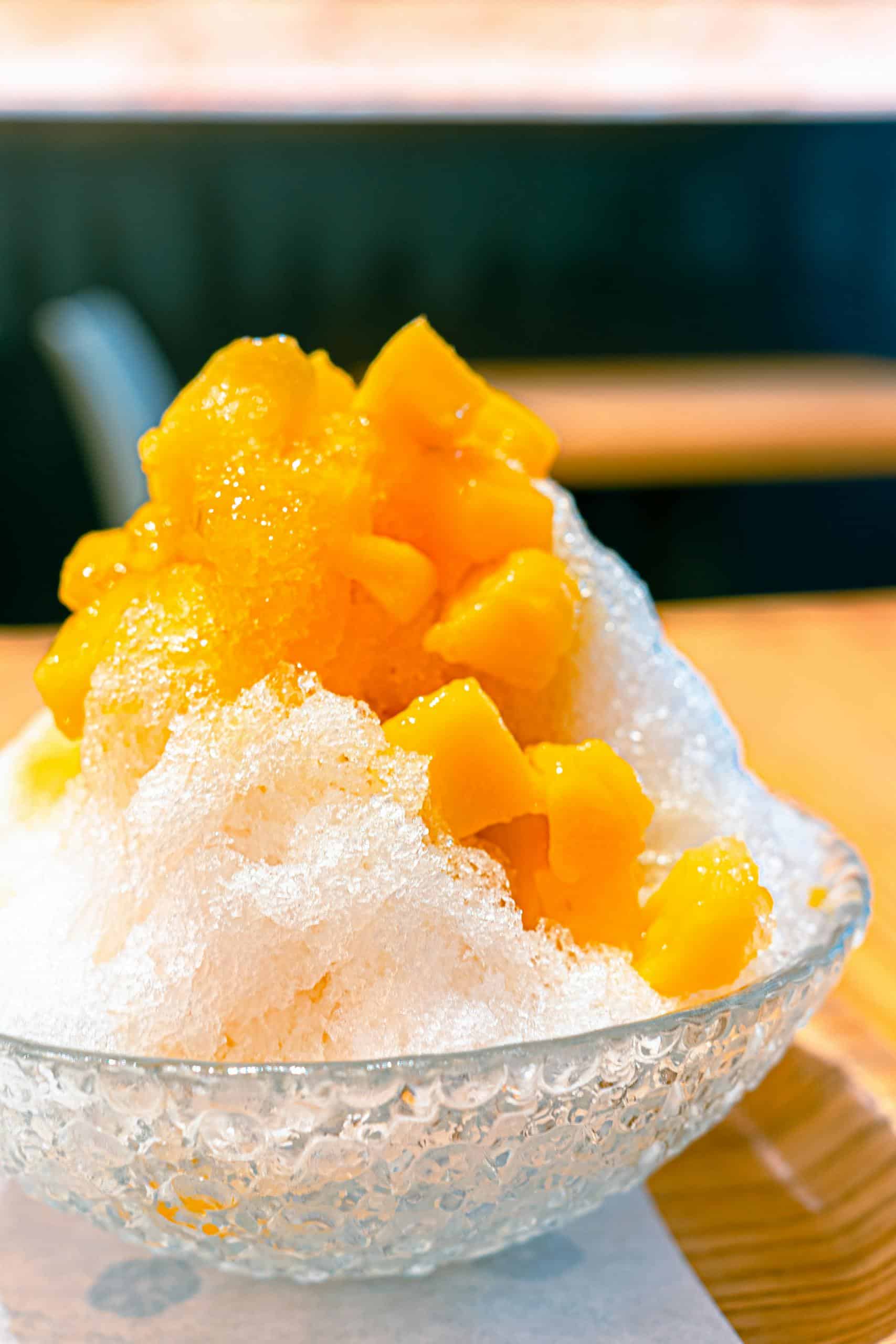 Close-up of a refreshing mango shaved ice dessert, highlighting vibrant colors and textures.