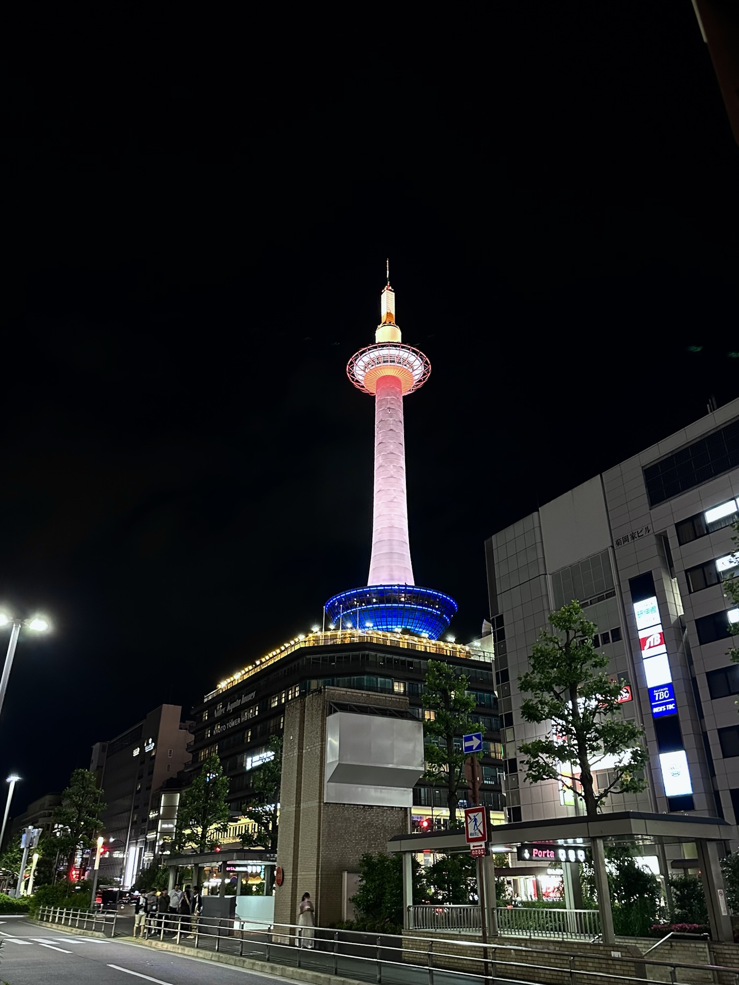 Kyoto Tower glowing pink and blue against the night sky near Kyoto Station