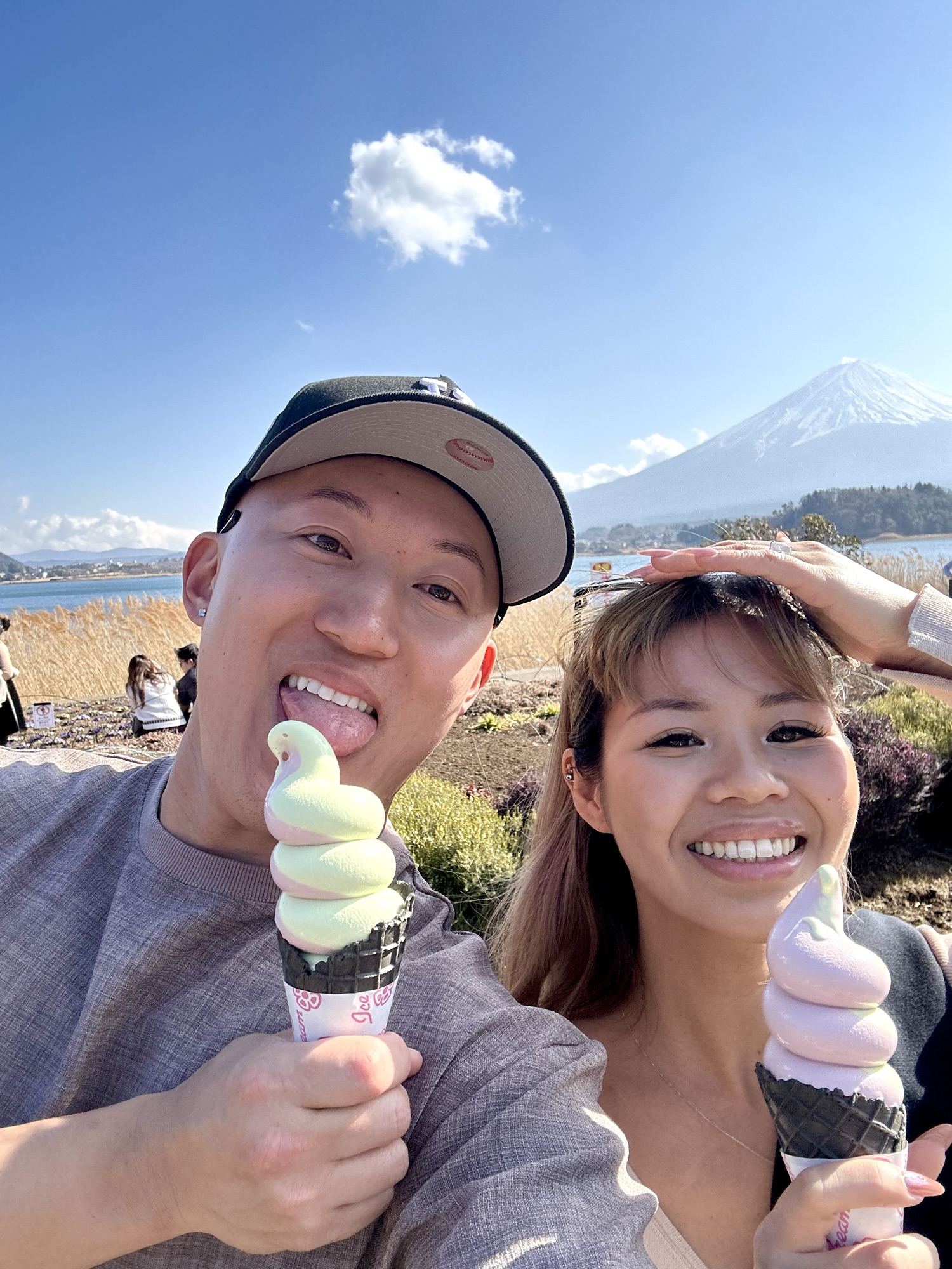 Audrey and Dennis eating ice cream at Oishi Park with Mount Fuji in the background on a sunny day