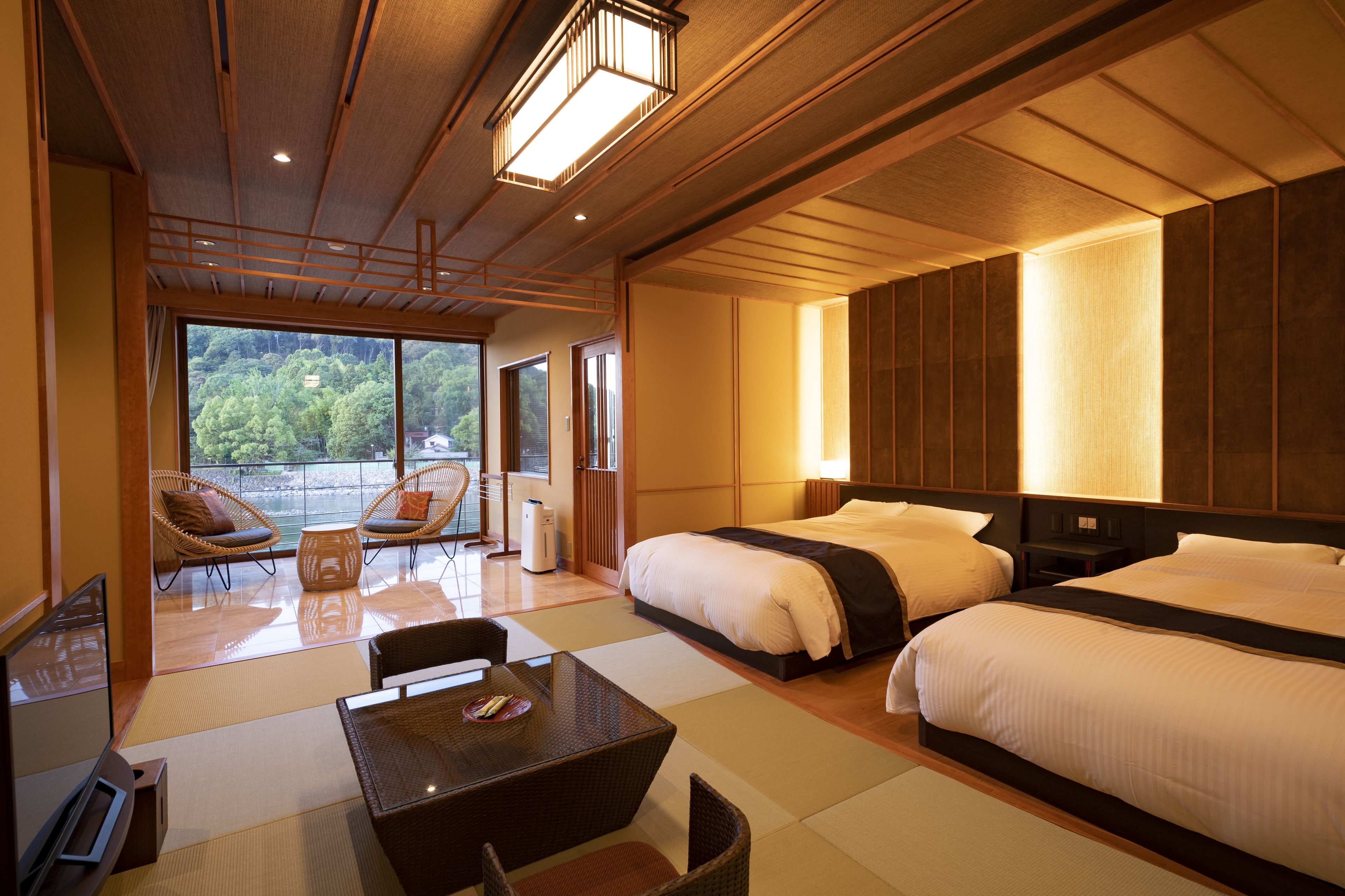 Spacious room at Hanayashiki Ukifune En with tatami seating, modern beds, and views of the Uji River
