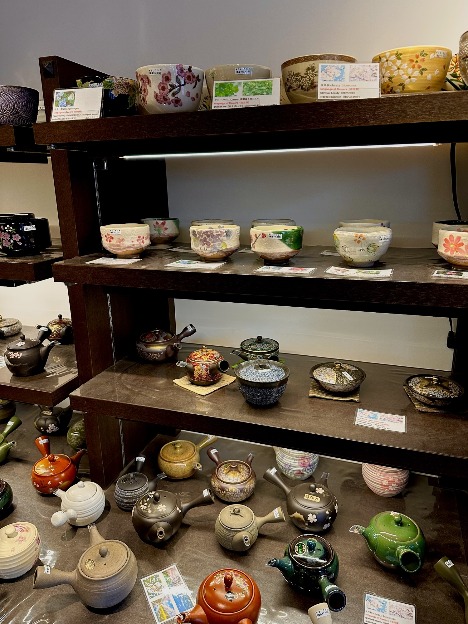 Shelves of handmade ceramic teapots and tea bowls inside a boutique shop in Uji