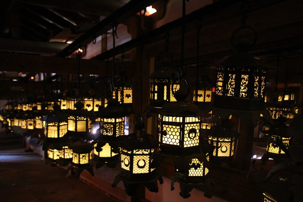 Hanging lanterns glowing inside Kasuga Taisha Shrine in Nara