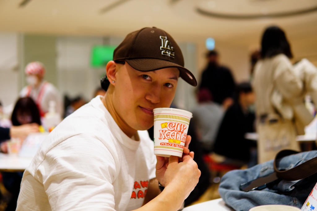 Dennis holding a custom Cup Noodles cup inside the Cup Noodles Museum