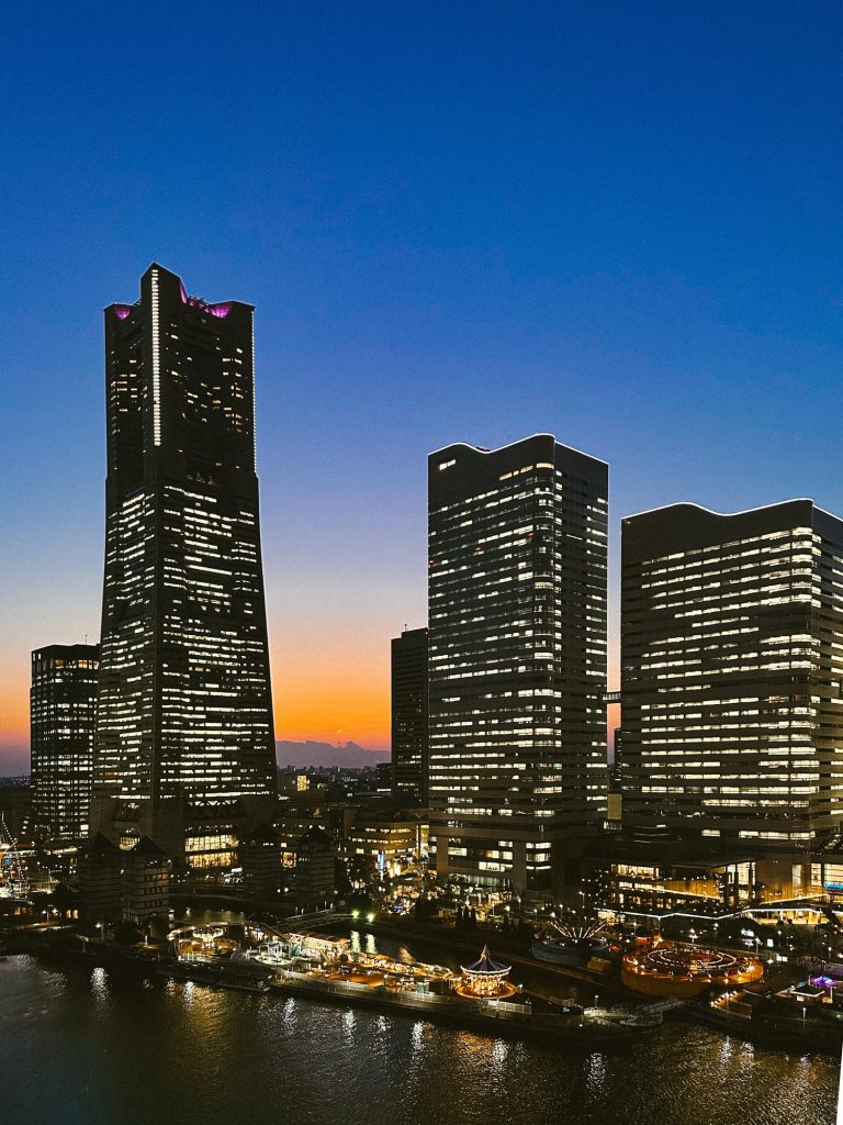 Yokohama skyline at sunset with Minato Mirai skyscrapers, waterfront lights, and Cosmo World.